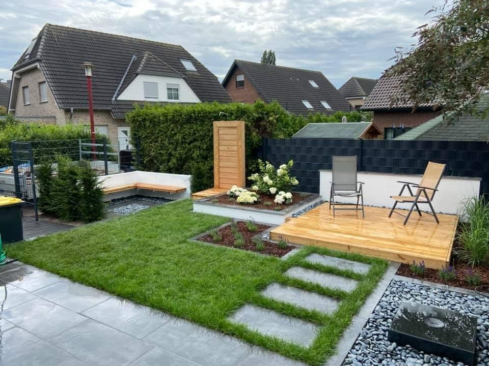 Garten mit Holzdeck, Außendusche, Sitzbank, Trittplatten im Rasen und Wasserspiel