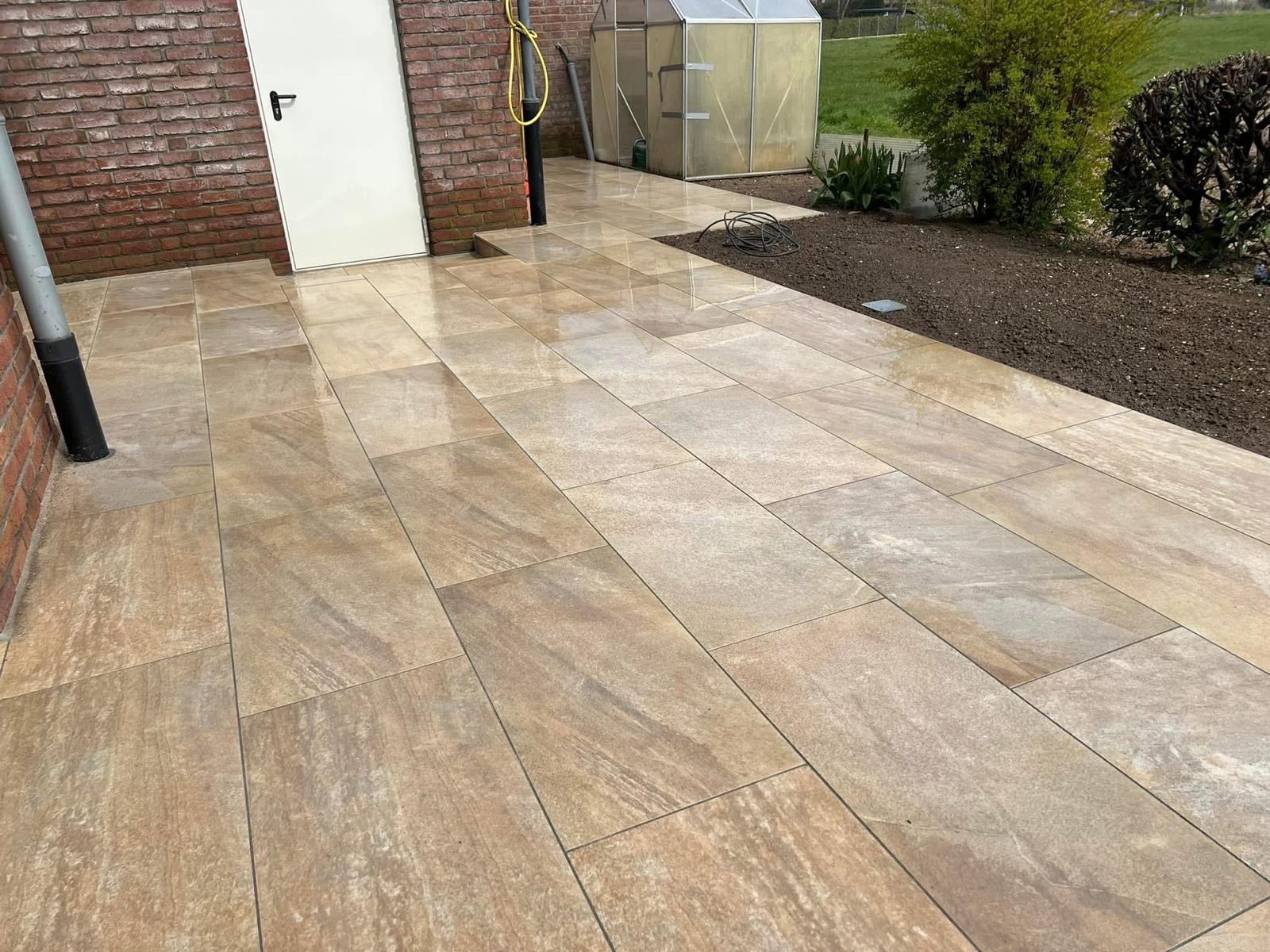 Terrasse aus großformatigen Keramikplatten in Sandtönen